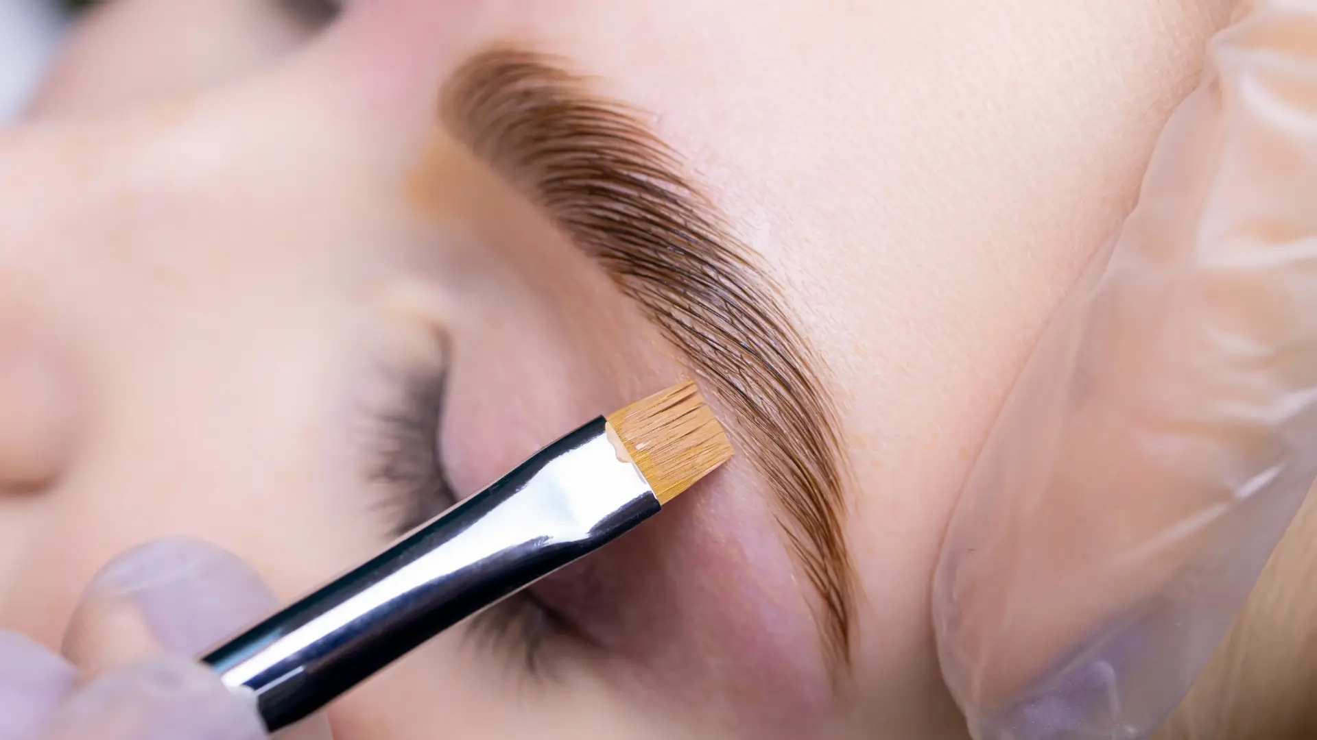 A PERSON APPLYING A EYEBROW BRUSH