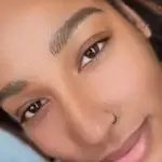 a woman smiling with a nose ring