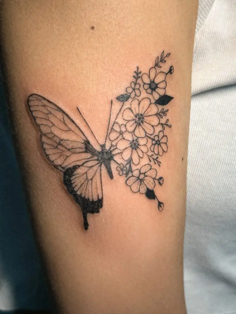 a tattoo of a butterfly and flowers on a person's arm